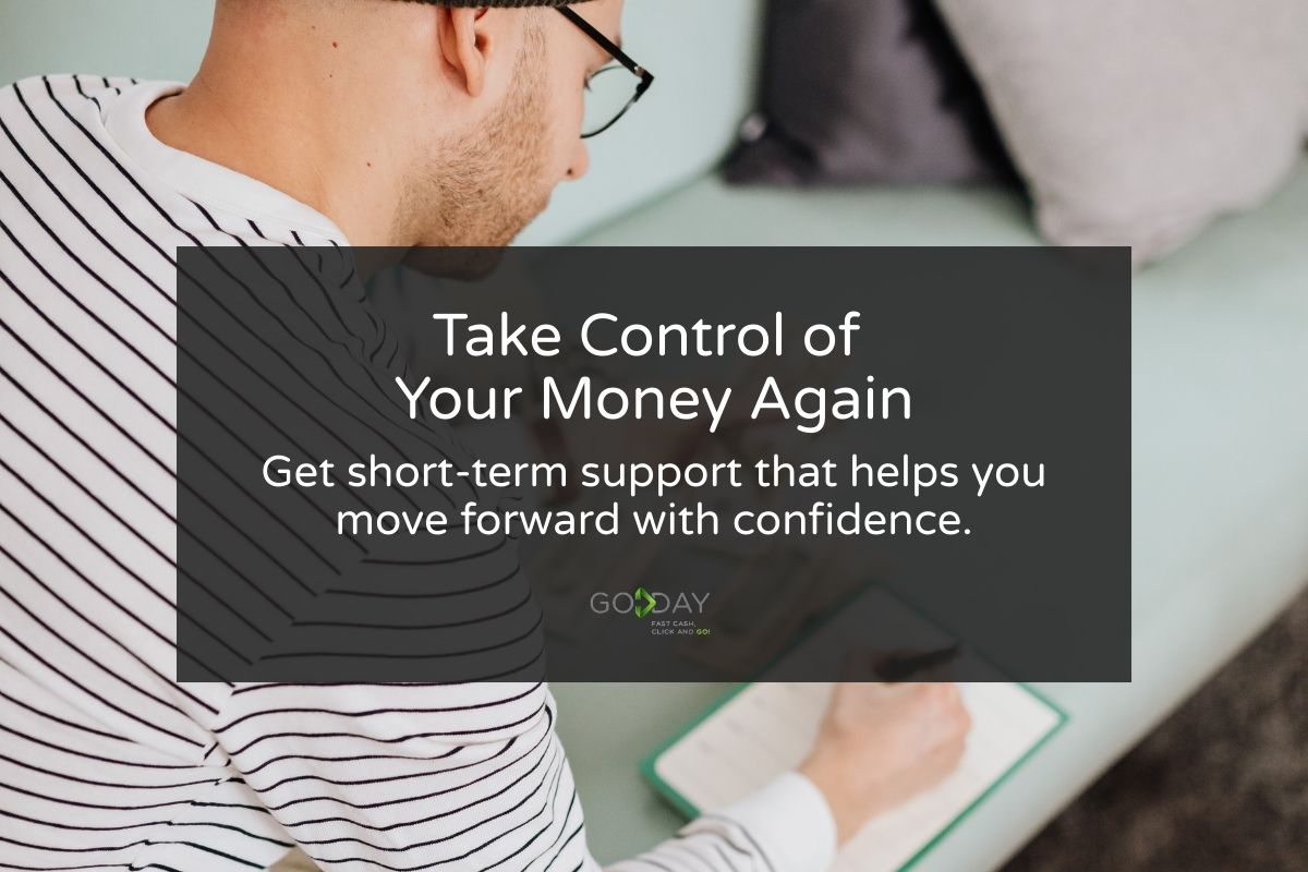 A person reviewing finances at home with a notebook and card, representing taking control of money with GoDay’s short-term support.